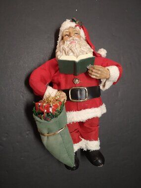 Sabre 7.5" Tall Resin Santa holding a Book & Christmas Gift Bag Material Suit